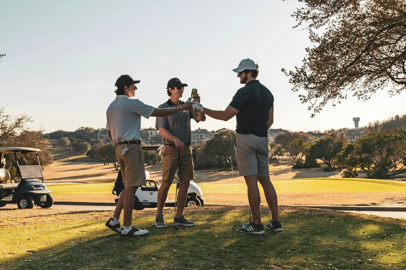 Three golfers greeting each other on the course